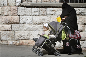 Orthodox woman covers her face with a shawl. Wlaking with her children in Mea Shearim. 27.02.2011. Photography: Miriam Alster, Flash 90 