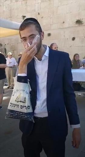 A young ultra-Orthodox man wipes his nose with a page from the Conservative prayerbook (photo credit: courtesy of the Conservative movement spokesman)