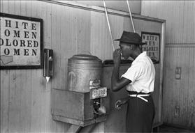 Man drinking from water cooler for ''colored people,'' courtesy of Wikipedia